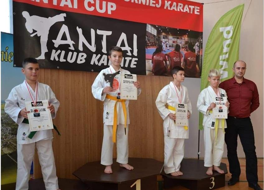 czterech stojących na podium uczestników turnieju karate