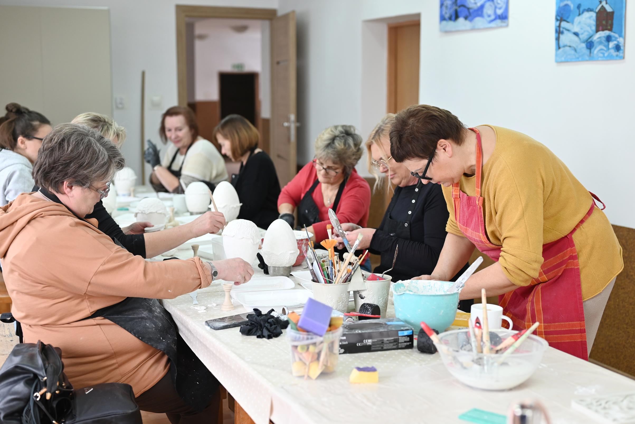 Prowadząca warsztaty wraz z uczestniczkami skupionymi nad swoimi pracami