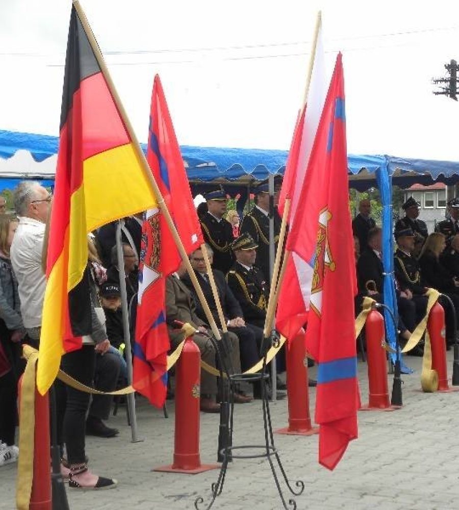 Siedzący goście  obserwują  zawody strażackie