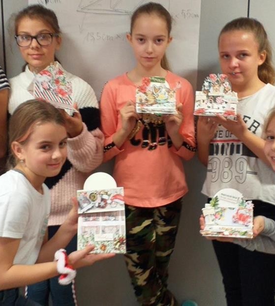 grupa dziewczynek prezentuje kompozycje papierowe wcześniej wycinane i sklejane    