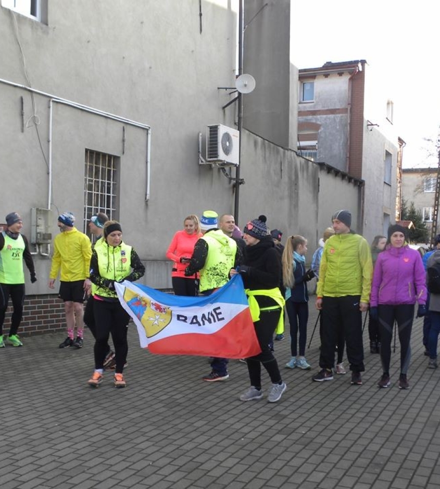 stojąca grupa biegaczy i grupa Nordic walking dwoje z nich trzyma flagę BANI
