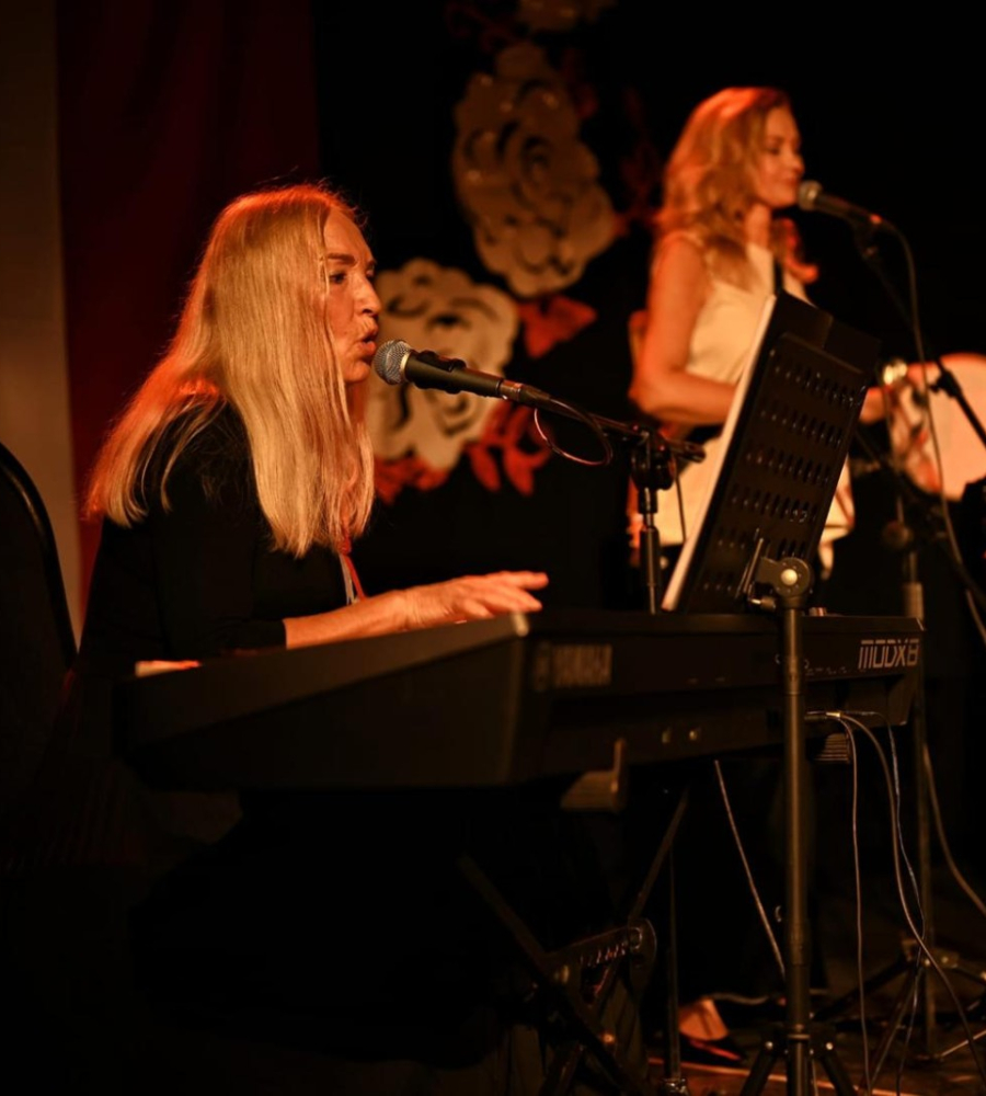 Panie śpiewają i grają na instruentach na koncercie podczas świętowania Dnia Niepodleglości