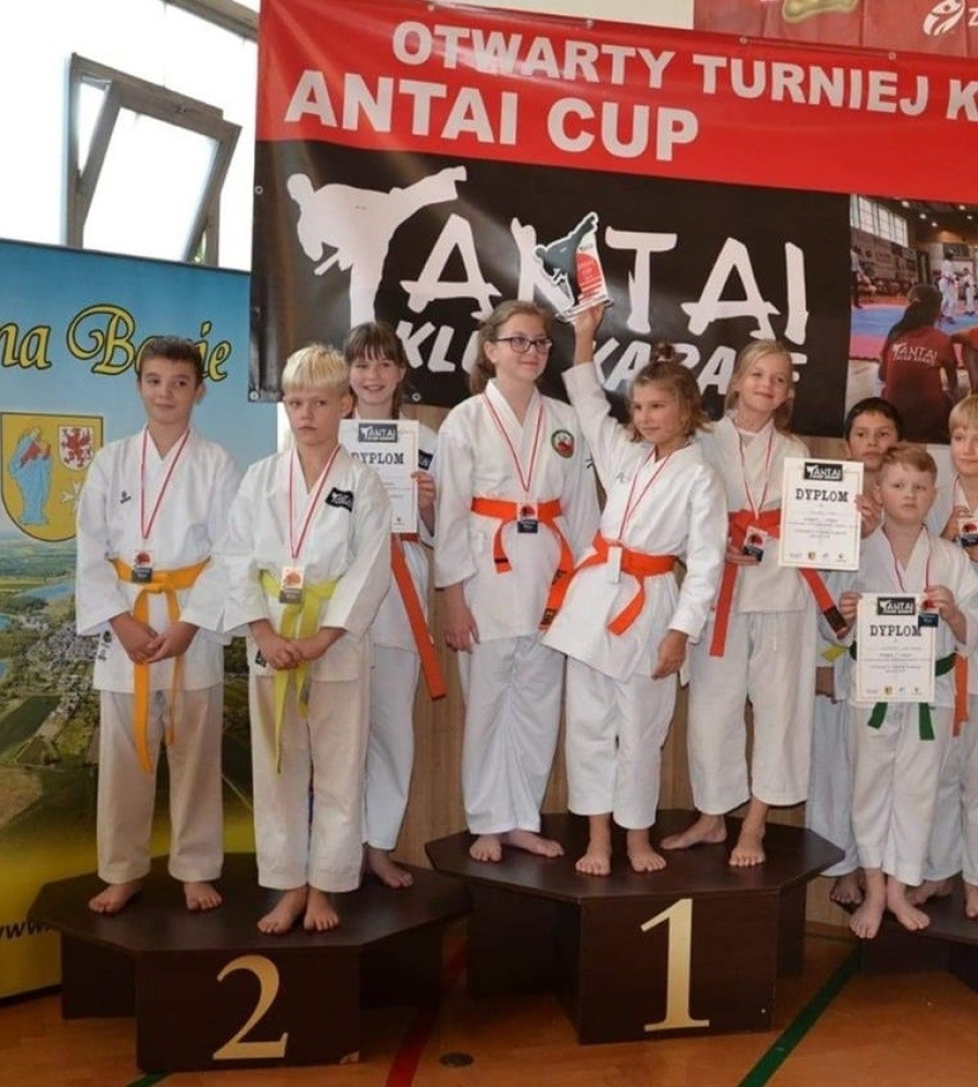 dziecięce drużyny karate stojące na podium